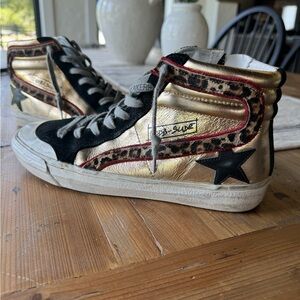Golden Goose Mid Star in black suede and shiny gold with leopard fur trim.
